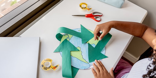 Fille créant une carte du monde en papier avec des fournitures de la marque Scotch™
