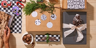 Création de décorations de cadeaux à partir d'éléments naturels et verts tels que des pommes de pin ou du houx
