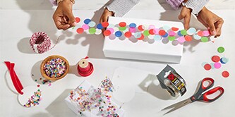 Emballage d'une boîte cadeau avec du ruban confetti fabriqué en collant du confetti coloré sur du ruban adhésif Scotch®
