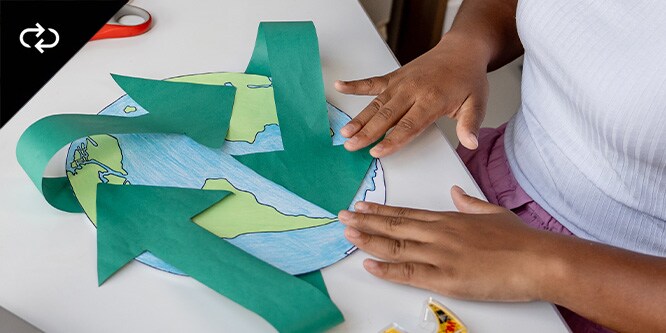 Un enfant en train de fabriquer une carte du monde en papier avec du ruban adhésif Scotch™
