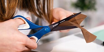 Fille découpant du papier avec des ciseaux Scotch™

