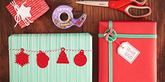 Créer un look d'emballage cadeau de Noël traditionnel avec des couleurs rouges, vertes et blanches, et attacher des figures en papier avec le ruban adhésif double face Scotch®
